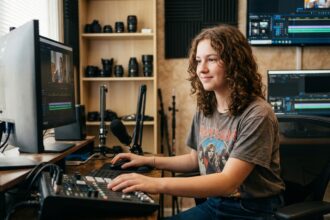 Jeune femme en studio de montage vidéo concentrée