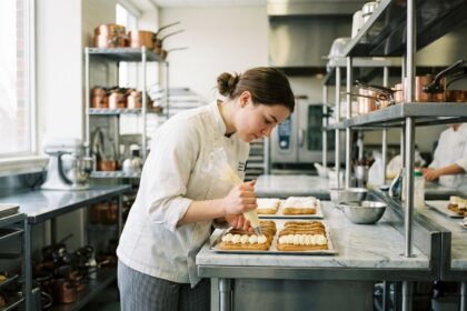 Jeune femme en cuisine décorant des éclairs avec précision